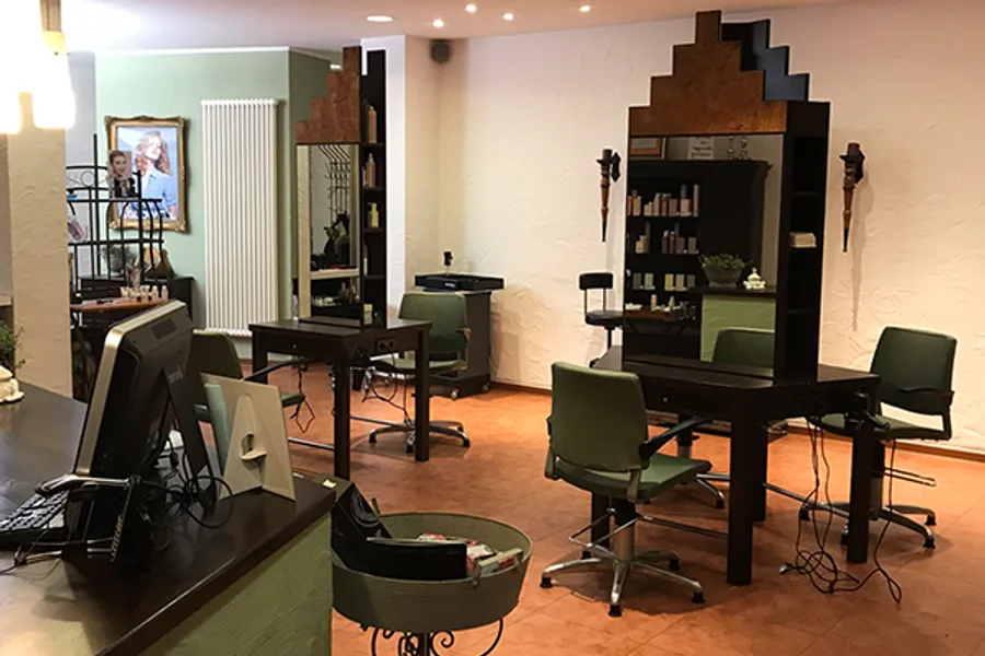 Bedienplätze im Salon Colohrum Haar mit Spiegeln und Holzmöbeln